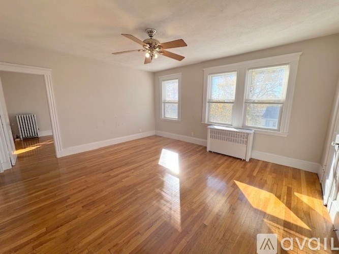 A room with wooden floors and a ceiling fan.