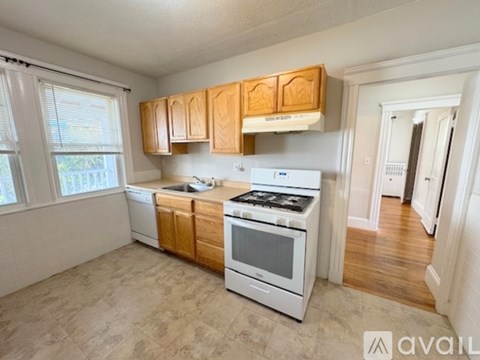 A kitchen with white appliances and wooden cabinets.