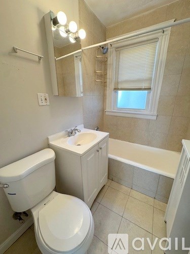A bathroom with a toilet, sink, and bathtub.