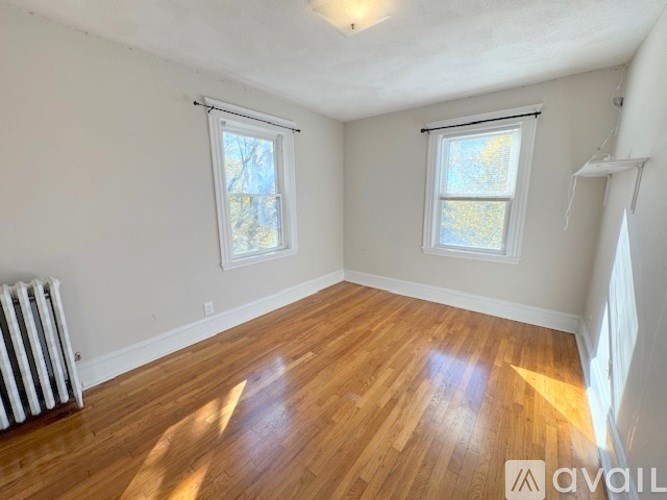 A room with wooden floors and two windows.