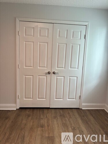 A white double door with a silver handle is closed.