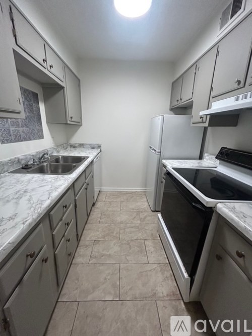 A kitchen with a white fridge and a white counter top.