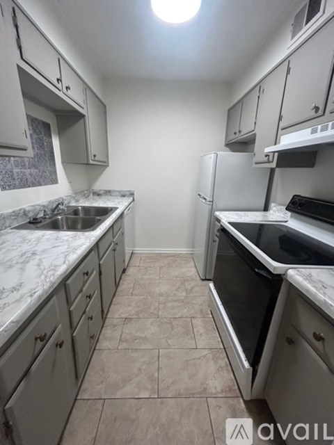 A kitchen with a white fridge and a white counter top.