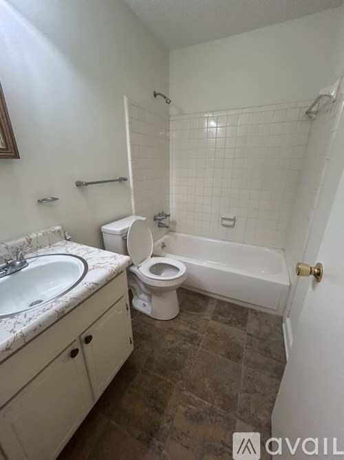 A bathroom with a toilet, sink, and bathtub.