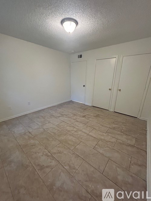 A room with a tiled floor and two doors.