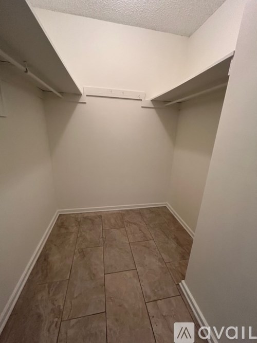 A small, empty room with tiled flooring and white walls.