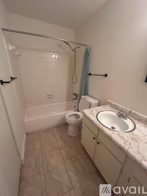 A bathroom with a toilet, sink, and bathtub.
