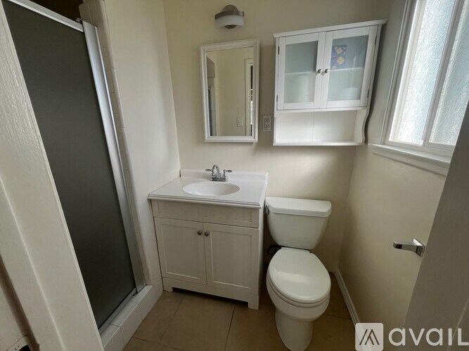 A bathroom with a toilet, sink, and medicine cabinet.