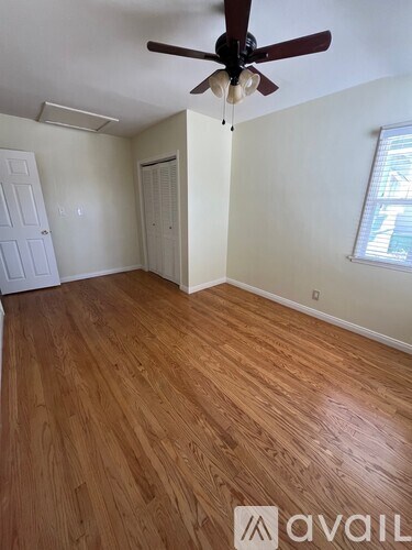 A room with wooden flooring and a ceiling fan.