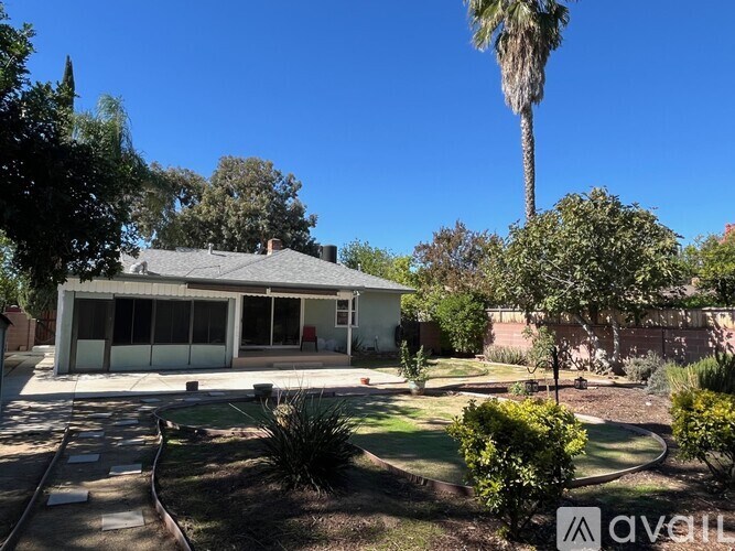 A house with a white garage and a palm tree in front.