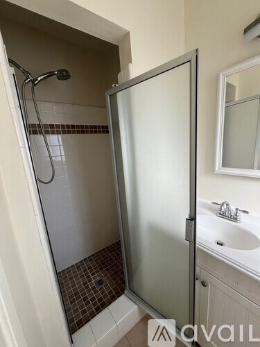 A bathroom with a glass shower door and a white sink.
