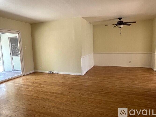 A room with wooden flooring and a ceiling fan.
