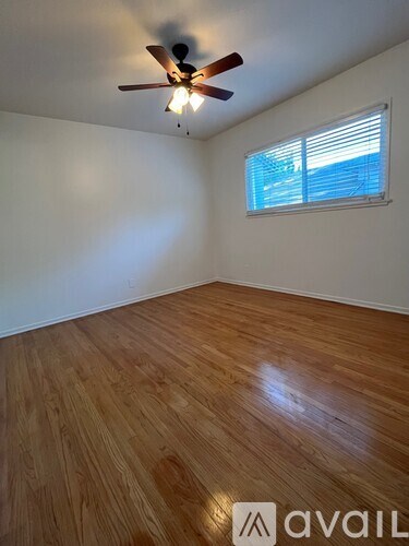 A room with wooden flooring and a ceiling fan.