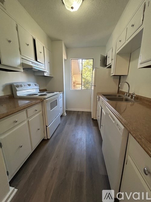 A kitchen with white cabinets and a window.
