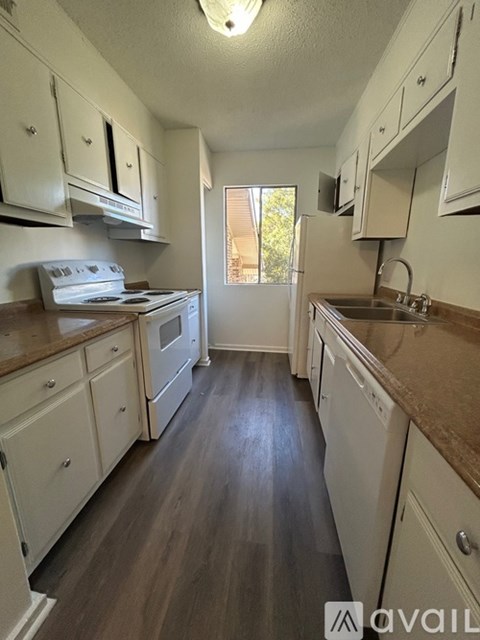 A kitchen with white cabinets and a window.