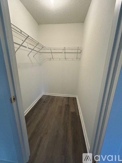 A hallway with a blue door and a white wall.
