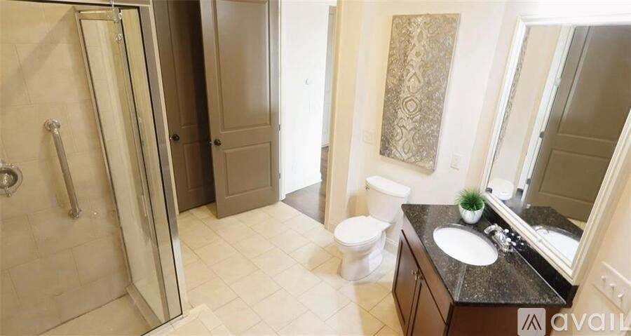 A bathroom with a sink, mirror, toilet, and shower.