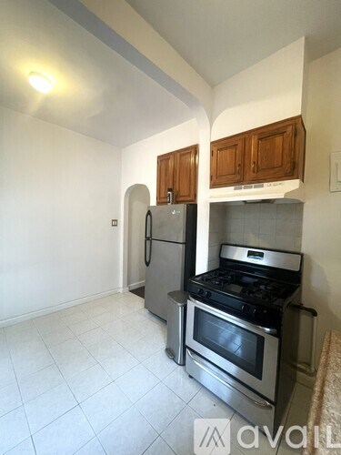 A kitchen with a stove, refrigerator, and cabinets.