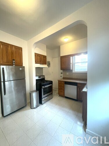 A kitchen with a refrigerator, oven, and sink.