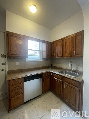 A kitchen with wooden cabinets and a white dishwasher.
