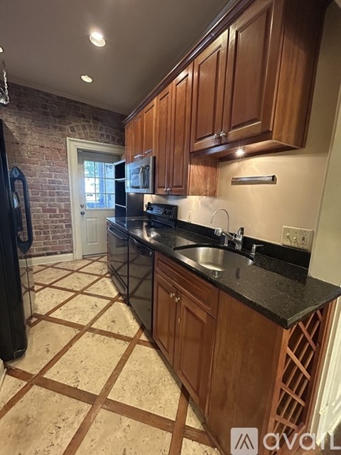 A kitchen with wooden cabinets and a black countertop.
