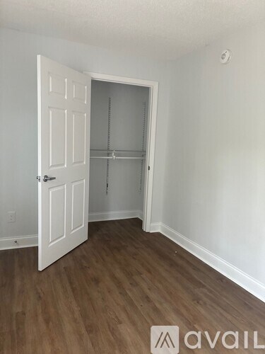 A room with a white door and a shelf in it.