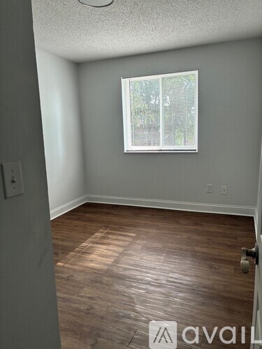 A room with a window and wooden flooring.
