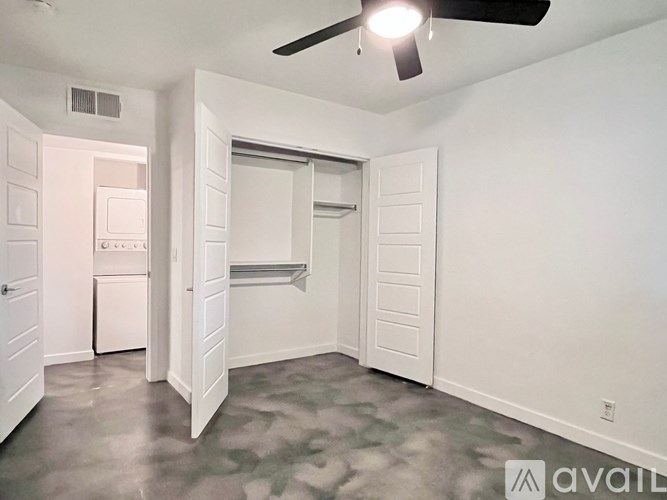 A room with a ceiling fan and a door leading to another room.