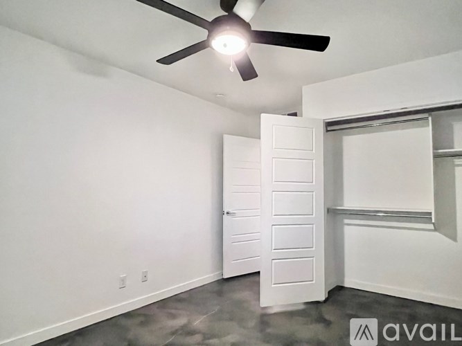 A room with a ceiling fan and a white door.