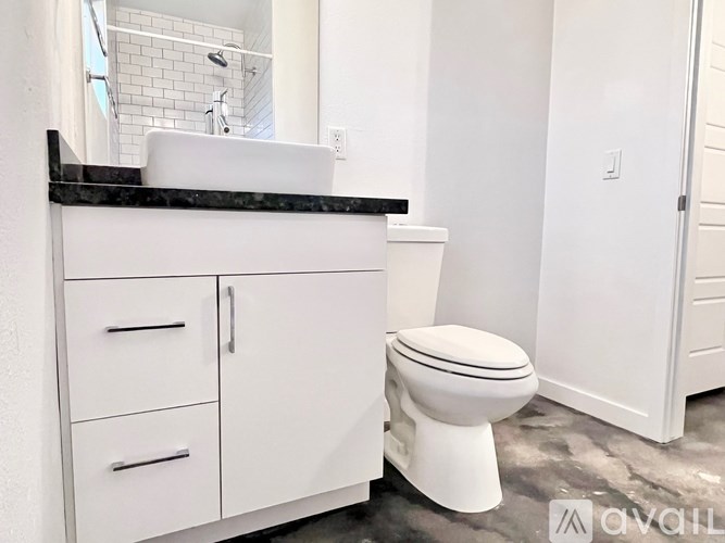A white toilet sits next to a white sink in a bathroom.