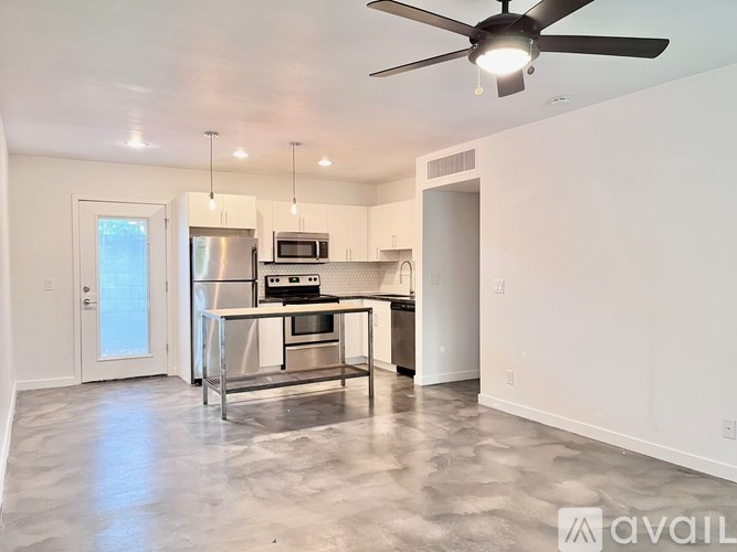 A modern kitchen with a central island and stainless steel appliances.