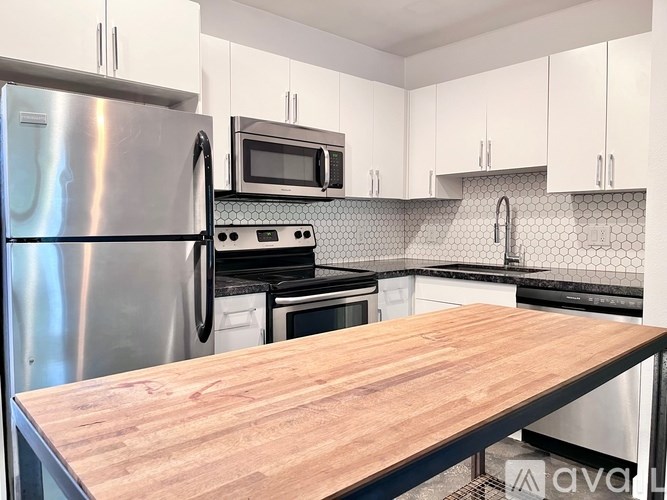 A kitchen with a wooden countertop and stainless steel appliances.