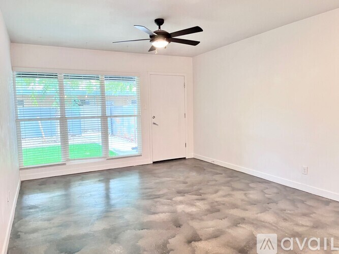 A room with a ceiling fan and a door leading to a balcony.