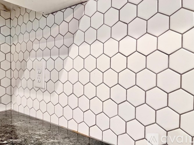 A white tile wall with a hexagonal pattern.