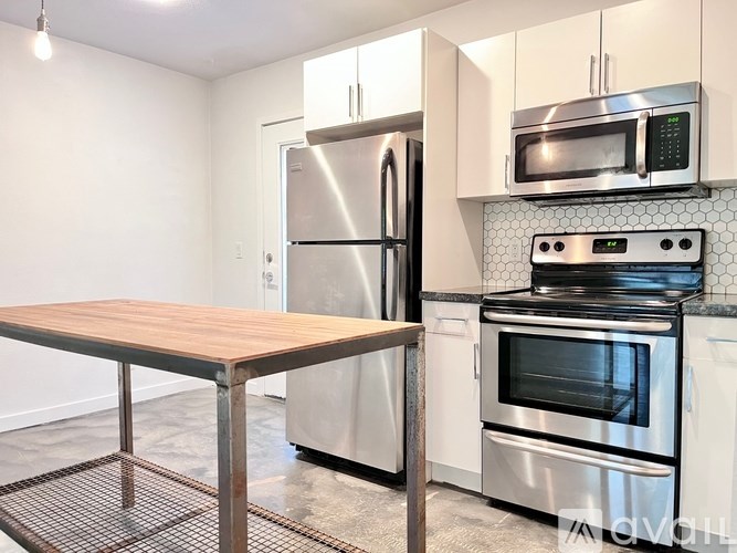 A kitchen with a stainless steel refrigerator, oven, and microwave.