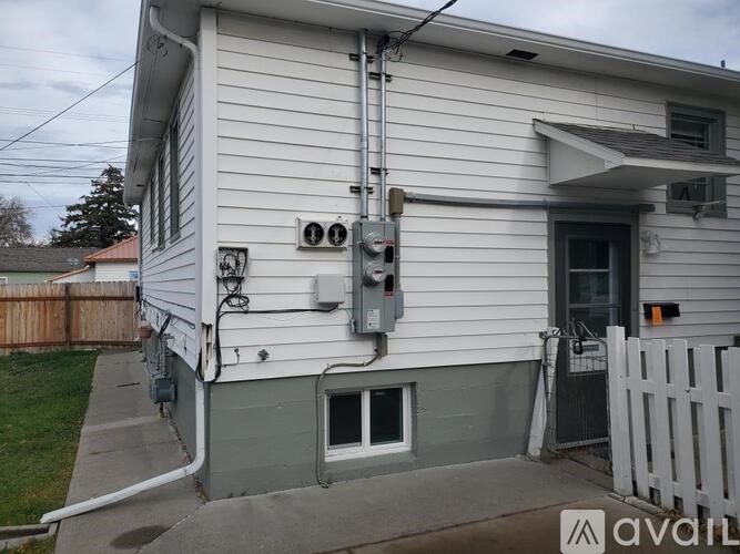 A house with a grey front and a white picket fence.