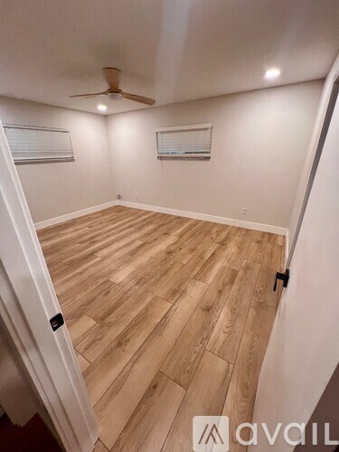 A room with wooden flooring and a ceiling fan.