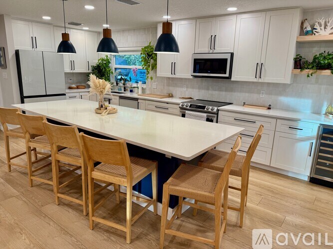 A kitchen with a white table and chairs.