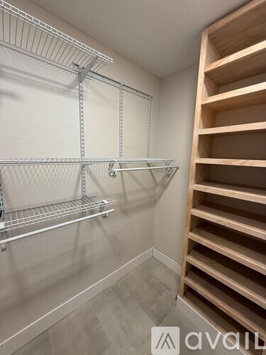 A walk-in closet with shelving and a wooden staircase.