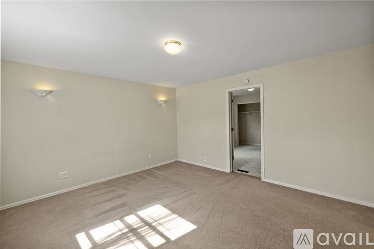 A room with a carpeted floor and a doorway leading to another room.