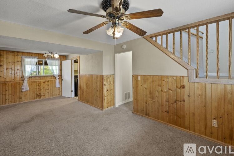 A room with wooden walls and a ceiling fan.