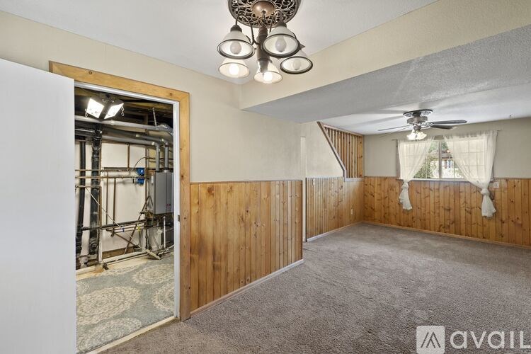 A room with wooden walls and a ceiling fan.