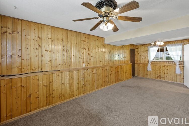 A room with wooden walls and a ceiling fan.