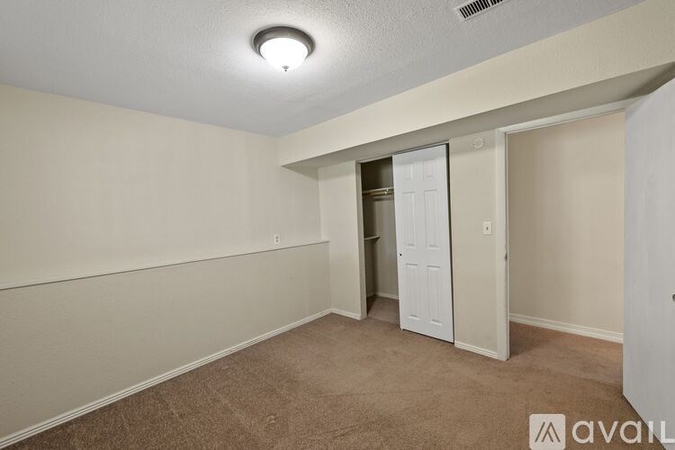 A room with a carpeted floor and a white door.