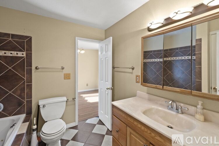 A bathroom with a toilet, sink, and mirror.