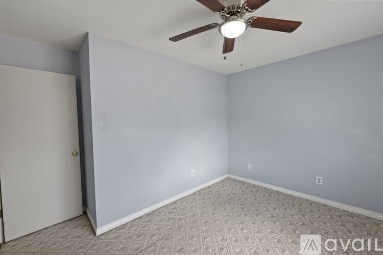 A room with a ceiling fan and a carpeted floor.