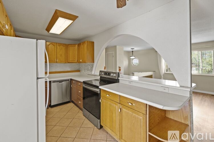 A kitchen with wooden cabinets and a white refrigerator.