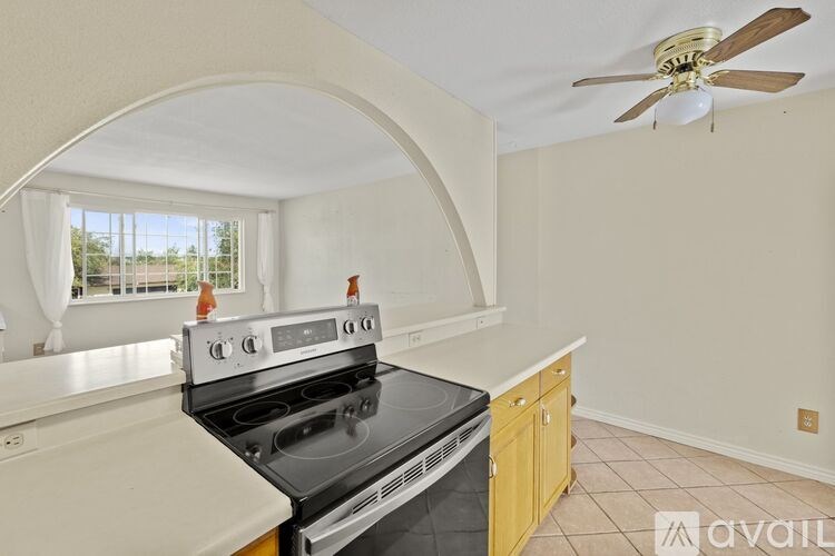 A kitchen with a stove top oven and a fan.