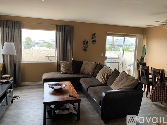 A living room with a brown couch and a wooden coffee table.