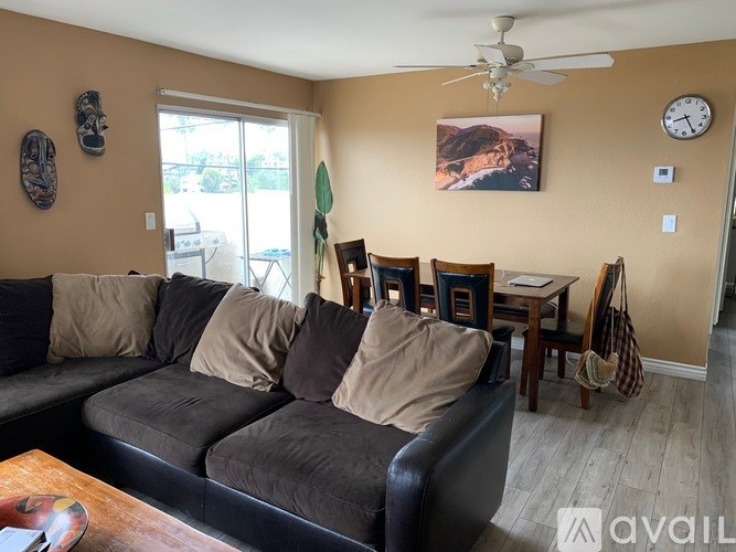 A living room with a grey couch, a coffee table, and a painting on the wall.